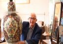 Mike Hicks, owner, at the Stalham Antiques Gallery, with a late 19th century polycrome delft vase