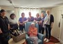 Staff members at Woodspring House nursing home in Fakenham with resident Betty Brown, 94, and a hamper, which is a raffle prizes in a fundraiser for earthquake victims.
