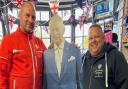 Great Massingham postmaster Mark Eldridge (right) posing with Lee Nicol, and a cardboard cutout of King Charles as the post office prepares to celebrate the coronation