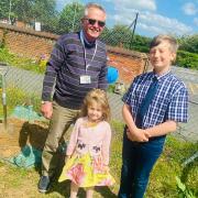 Dr Pickhaver, Chair of Governors, Armin Marosi Year six, and Madaline Sillis, Foundation Stage, bury the time capsule at Astley Primary School in Briston