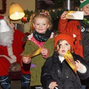 Happy children wave their golden tickets from Santa in ROARR! Dinosaur Adventure's Santa's Gotto. Picture: Danielle Booden