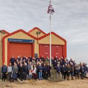 RNLI Wells crew members and their families at the old lifeboat station before the flag was lowered for the final time