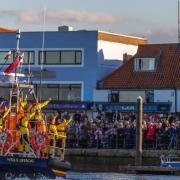 Thousands of people on Wells Quay cheer as the new lifeboat Duke of Edinburgh arrives in the town on October 8